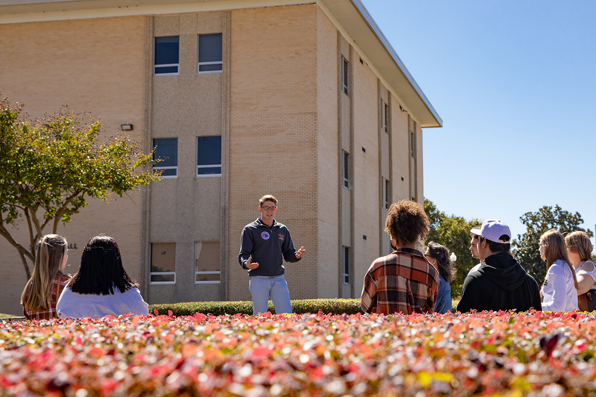 A Hawkseeker tour guide stands in front of a group of students on a ɫAV campus tour.